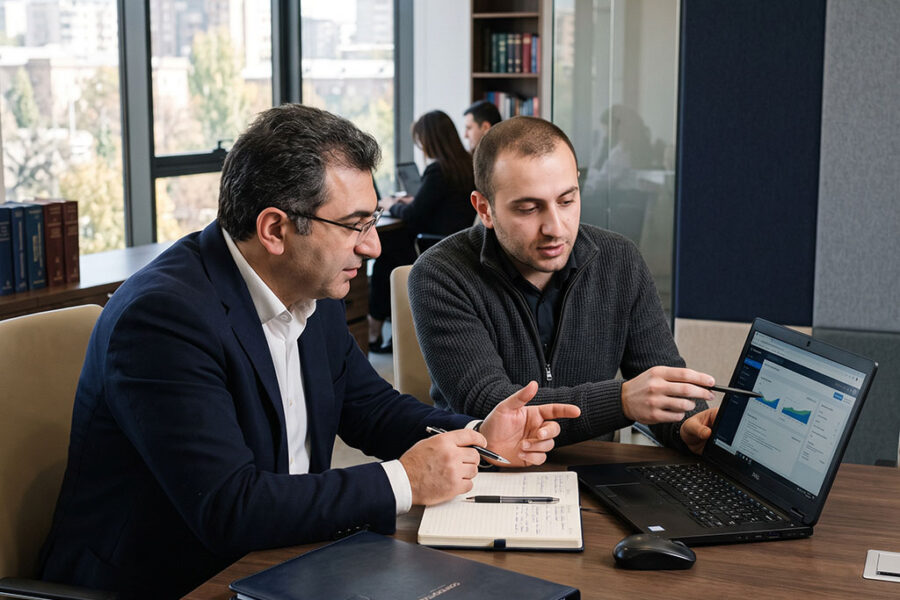 IT specialist assisting an attorney at a workstation in a law office