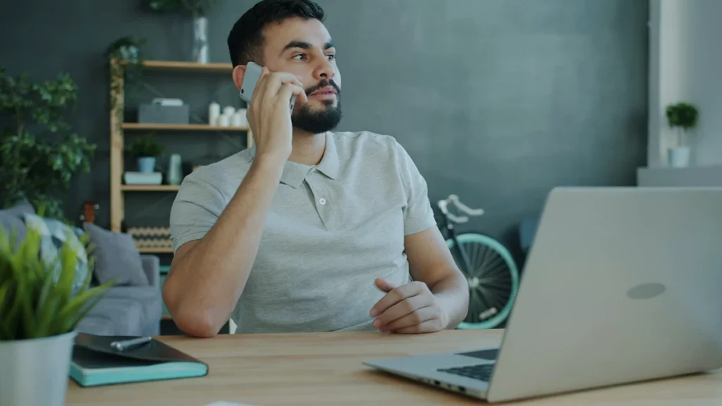 Business owner confirming new bank details by phone before a wire transfer